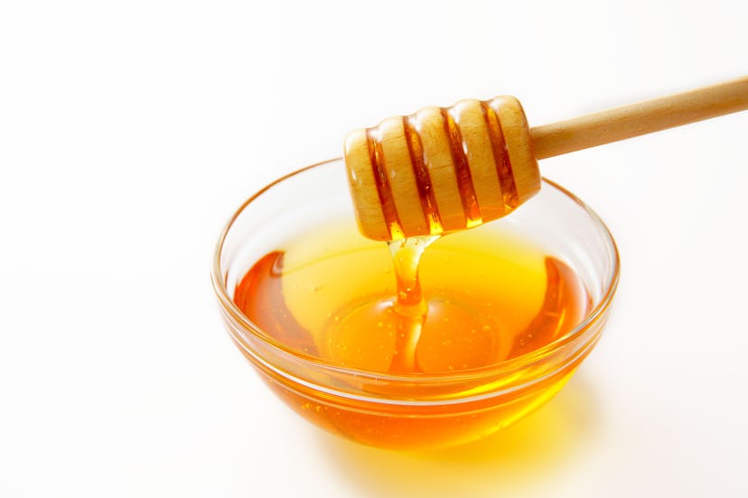 Honey with wooden honey dipper.
