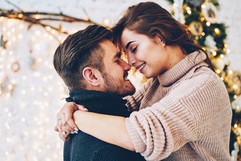 Romantic couple in love feeling happiness about their romance spending christmas eve together, woman...
