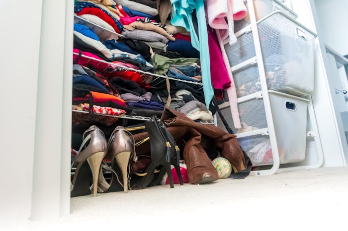 Real apartment closet organized and filled with woman's clothes, depicting shopping, lifestyle habit...