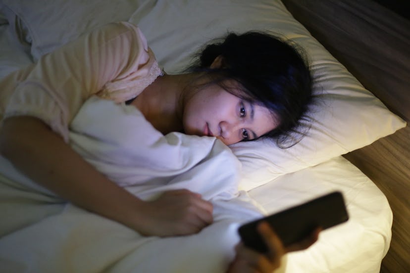indonesia girl using cell phone in bed