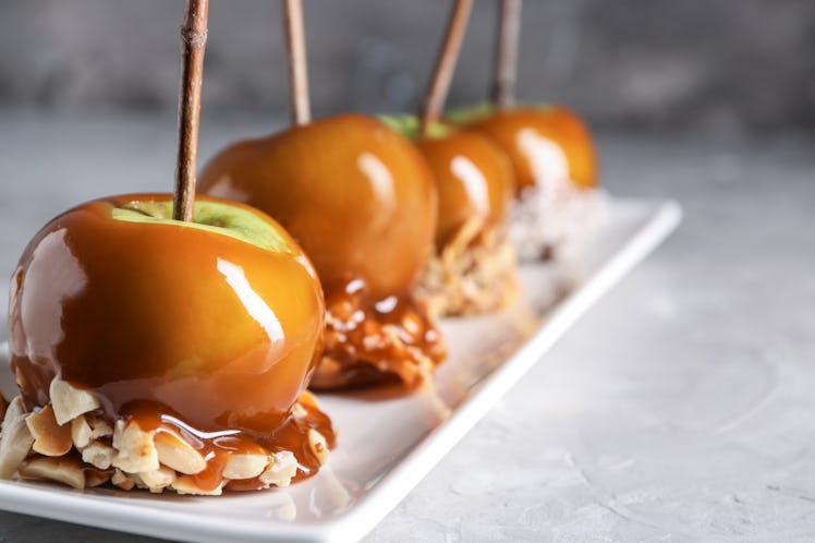 Delicious caramel apples with tree branches on plate