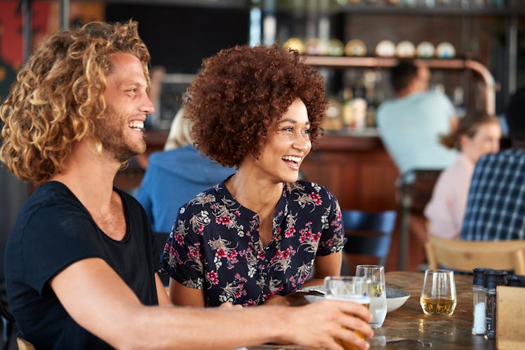 Couple On Date Meeting For Drinks And Food In Restaurant