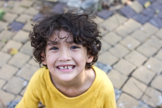 Curly hair mixed kid with natural loose tooth with toned color and lighting and selective focus