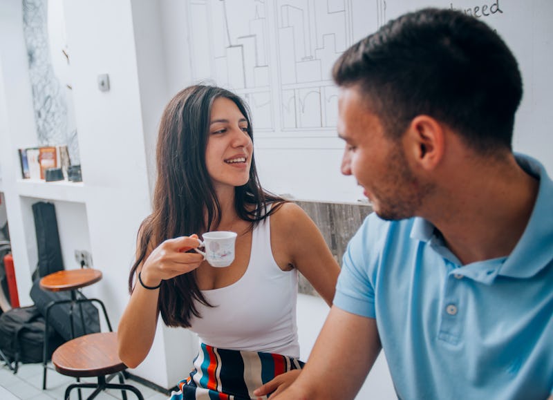 Good looking young couple laughing and having a good time on a date in a coffee shop