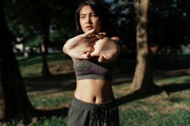 Portrait of a fitness woman doing warm up exercises outdoors