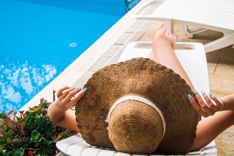 Girl sunbathes on a lounger by the pool