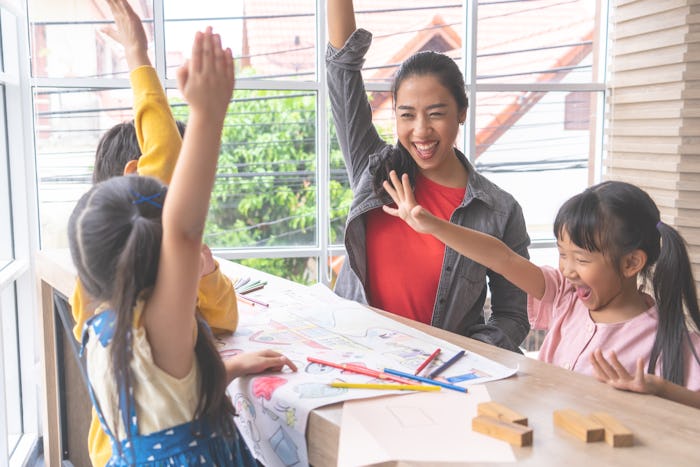 Teacher and Kindergarten students hand up for happiness
