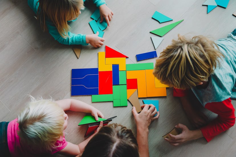 teacher and kids play with puzzle, doing tangram