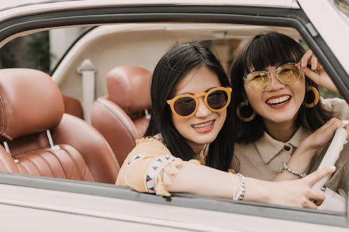 Happy friends driving vintage car