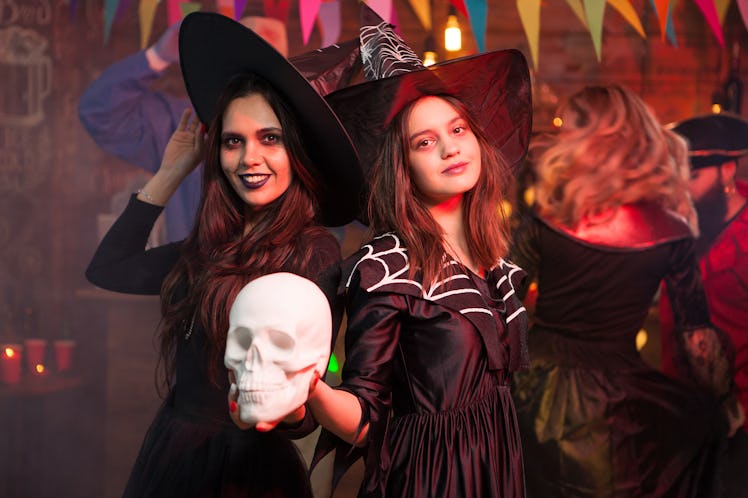 Portrait of two witches celebrating friendship at a halloween party. Halloween costume.