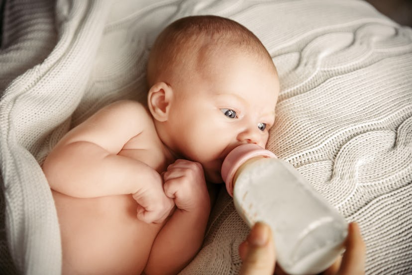 Newborn baby drinking out of a bottle