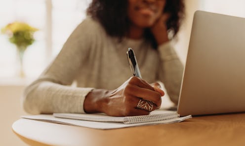 A woman working on laptop computer sitting at home. 