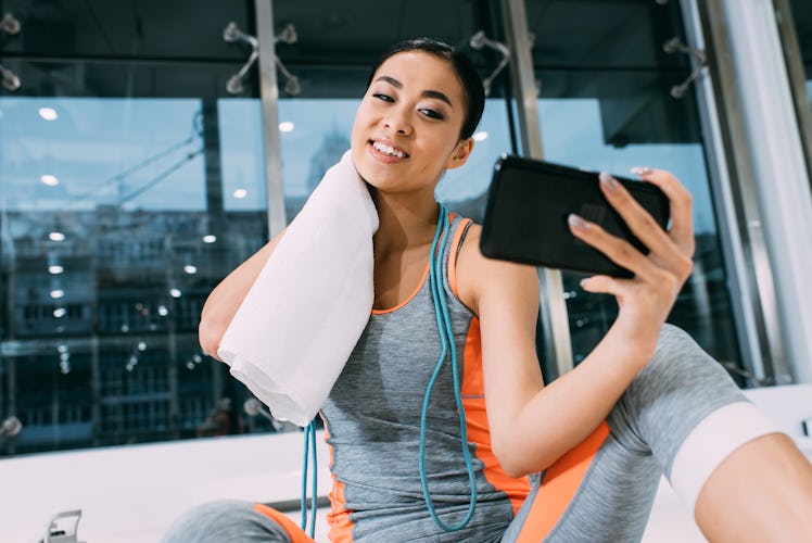 Young woman taking a selfie after a workout, in need of Instagram caption.