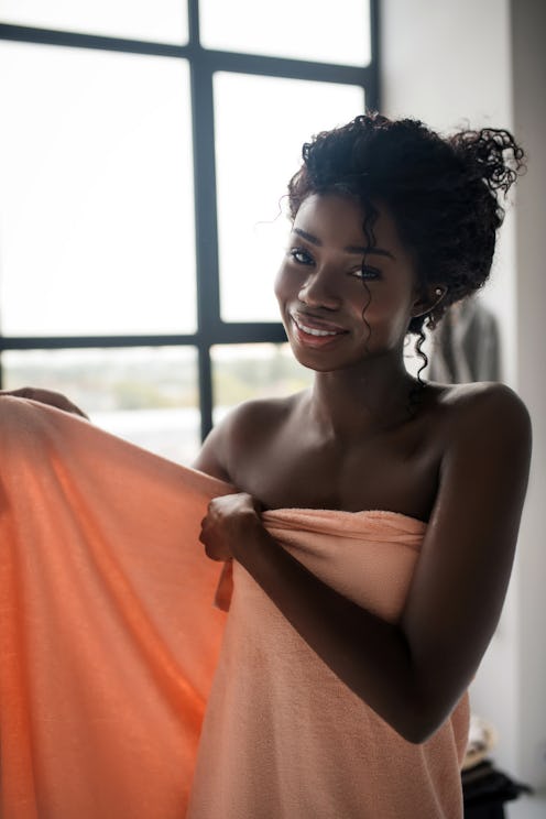 Feeling energetic. Woman smiling while feeling energetic after having bath with foam
