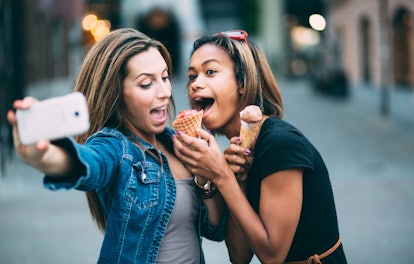 Multi ethnic Friends eating ice cream in city taking selfie