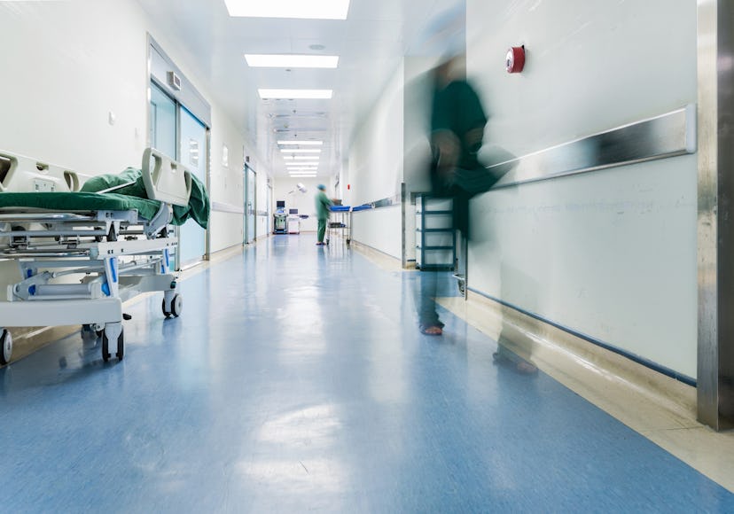 Doctors and nurses walking in hospital hallway, blurred motion. 