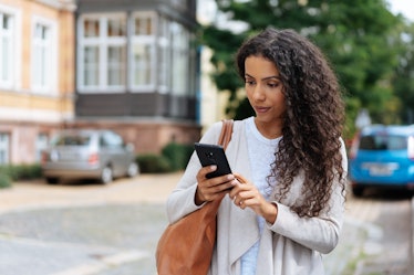 Young woman looking at phone at a text from someone who ghosted her