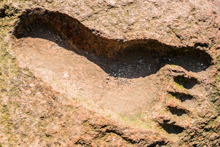 The imprint of a person's foot in granite. Big Foot. Footprint on the ground of the yeti.