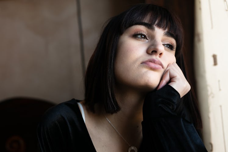 Sad teenager looks out the window