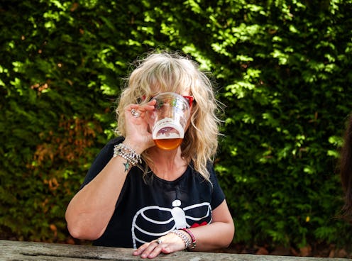 A woman drinking beer at an outdoor celebration