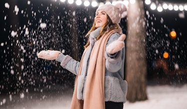 A beautiful girl is playing with snow before the 2019 New Moon In Sagittarius