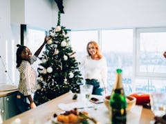 A couple decorates the tree in their apartment for the holidays.