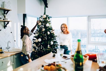 A couple decorates the tree in their apartment for the holidays.