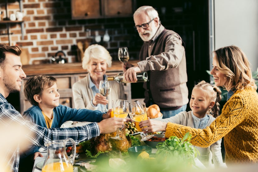 beautiful family clinking glasses of wine and juice on holiday dinner