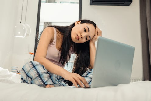 Working from home. Dark-eyed Asian freelancer feeling busy while working from home