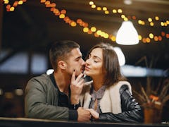 couple kissing in the restaurant while waiting for their food