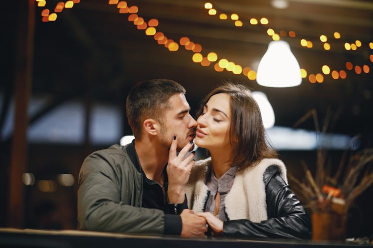 couple kissing in the restaurant while waiting for their food