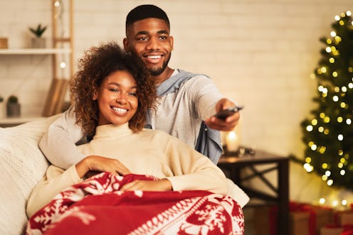 This couple cuddling under a blanket could be watching Disney+ on their Fire Stick. 