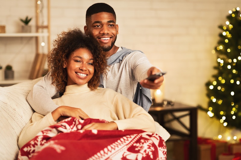 This couple cuddling under a blanket could be watching Disney+ on their Fire Stick. 