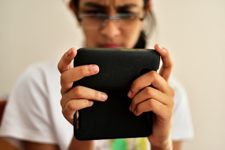 Indian teenage girl using whatsapp or chatting on her mobile phone. International Women’s Day. Mobil...