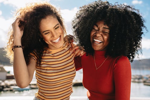 Cheerful young women enjoying a day out on the beach. Female friends having fun on the sea shore.