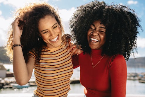 Cheerful young women enjoying a day out on the beach. Female friends having fun on the sea shore.