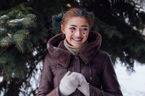 Winter portrait of a girl with bright make up and blue stars on face