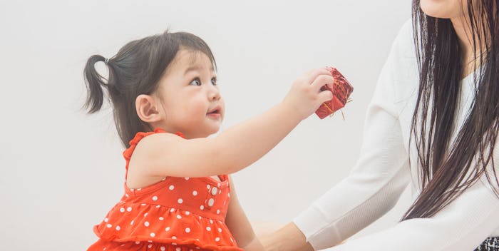 Little girl giving her mom a Christmas present
