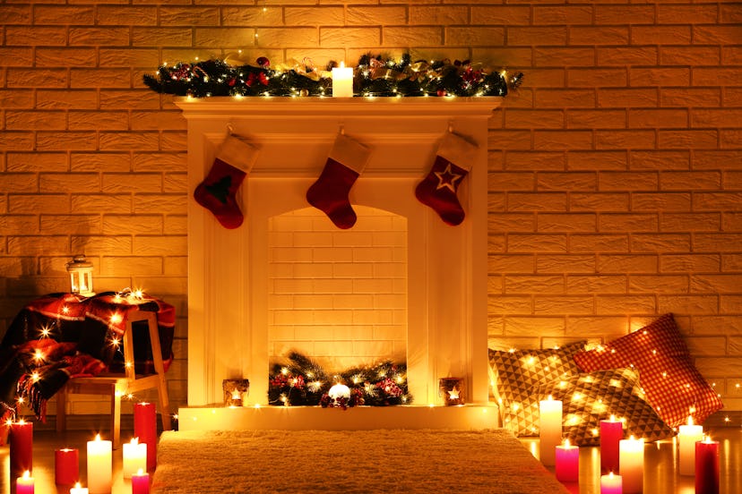 White decorated fireplace with stocking socks on brick wall background