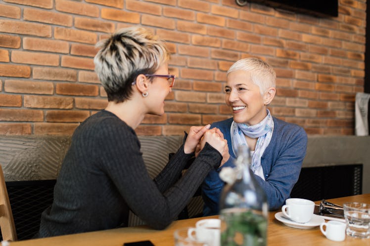 Senior mother sitting in cafe bar or restaurant with her middle age daughter and enjoying in convers...