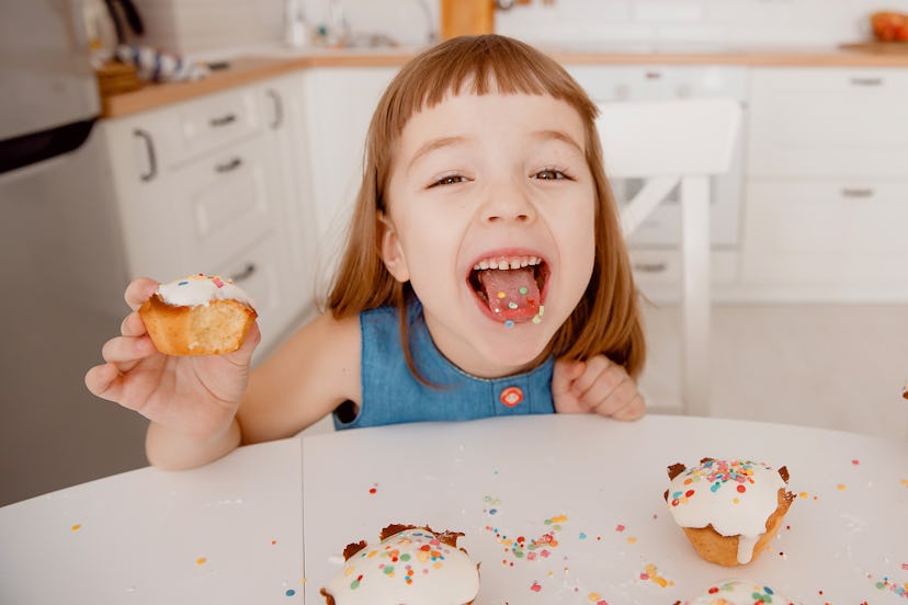 Close-up of color concentrates in tongue, in hand is a delicious cupcake, cooked by mom, fun and joy...