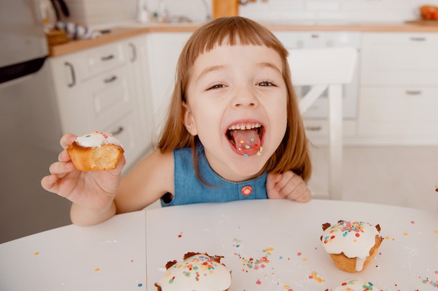 Close-up of color concentrates in tongue, in hand is a delicious cupcake, cooked by mom, fun and joy...