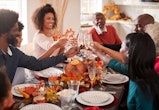 A Black family enjoying a Thanksgiving dinner in an article about Thanksgiving 2022 date