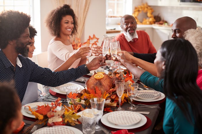 A Black family enjoying a Thanksgiving dinner in an article about Thanksgiving 2022 date