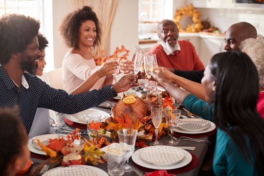 A Black family enjoying a Thanksgiving dinner in an article about Thanksgiving 2022 date