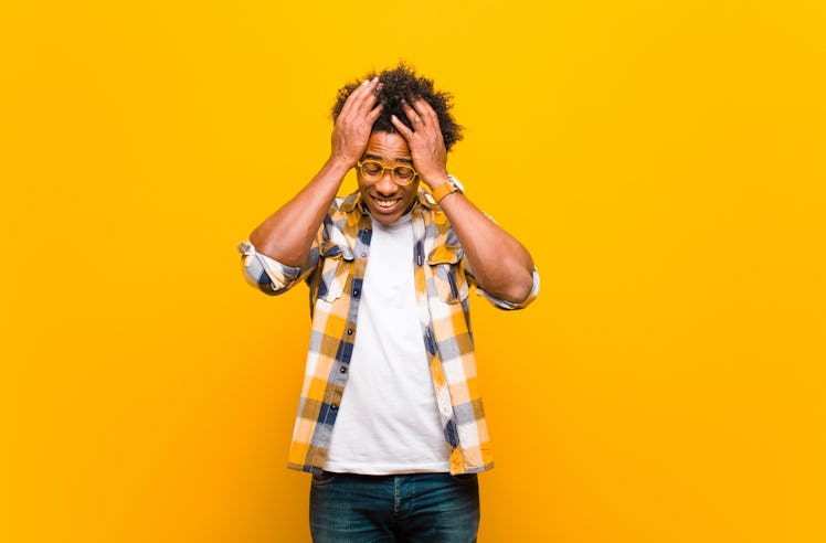young black man feeling stressed and anxious, depressed and frustrated with a headache, raising both...