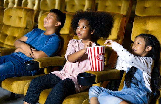 A group of kids watching a movie in a theatre 