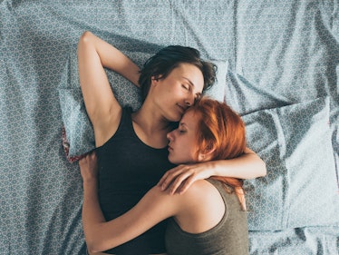 Women lying on the bed, young lesbians kisses and hugs
