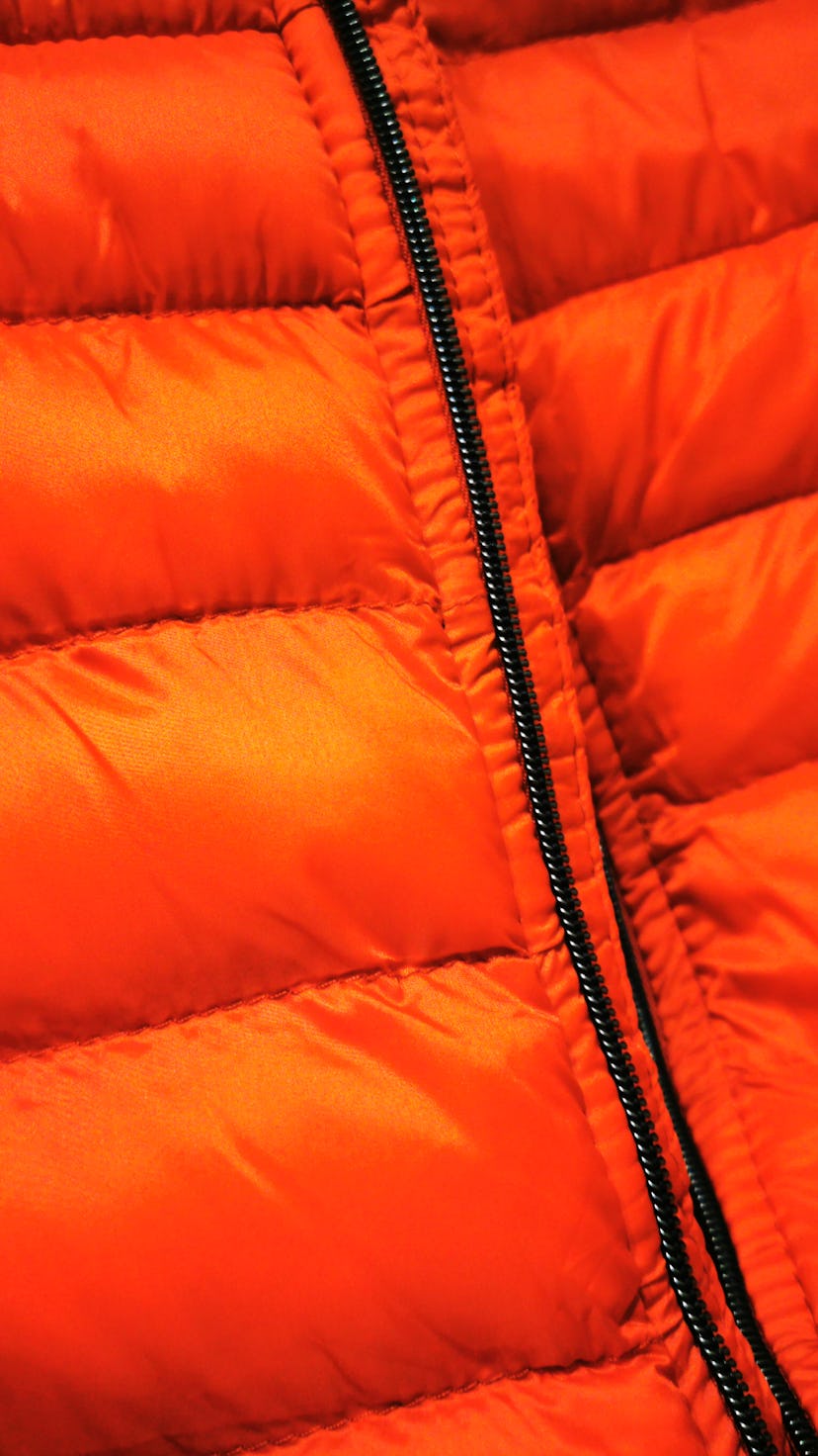 puffer jacket closeup in vivid bright red fabric material with black zip