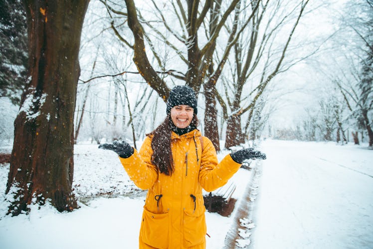 woman playing with snow in snowed city park